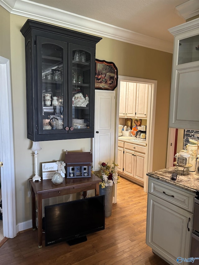 interior space with baseboards, crown molding, and light wood-type flooring
