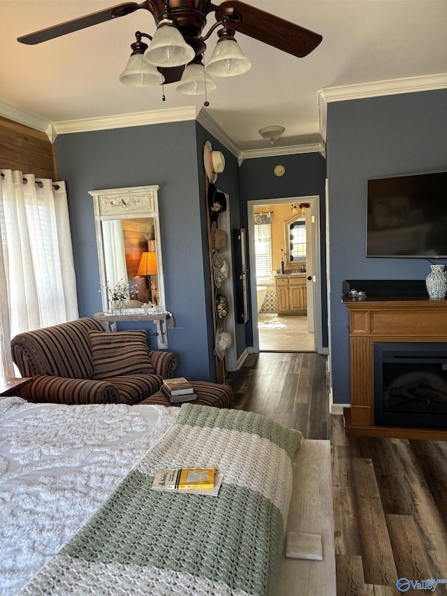 bedroom featuring a ceiling fan, wood finished floors, a fireplace, baseboards, and ornamental molding