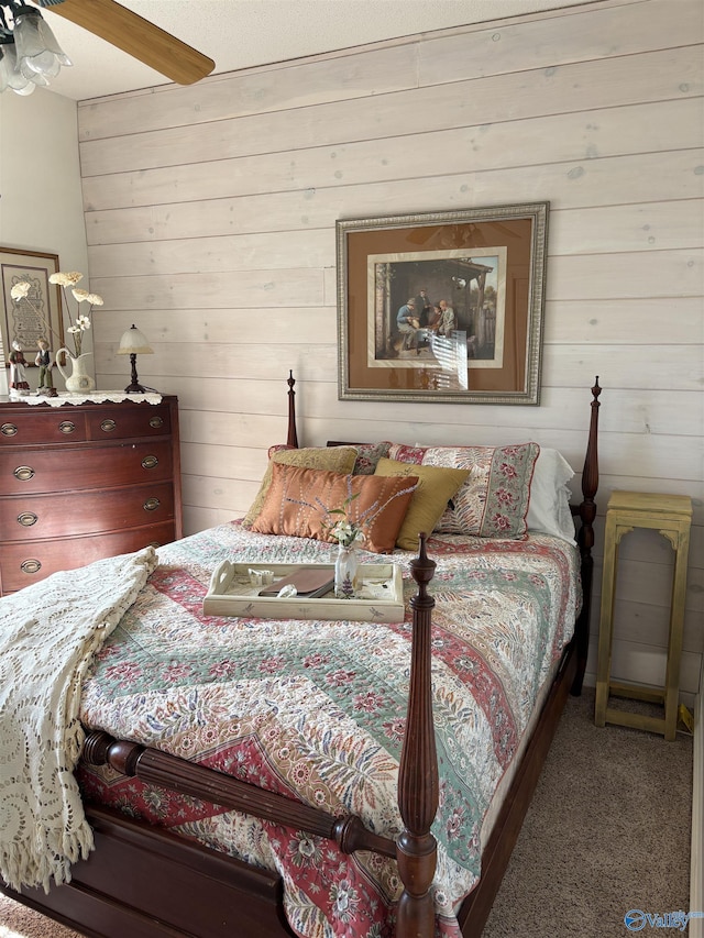 carpeted bedroom featuring wood walls