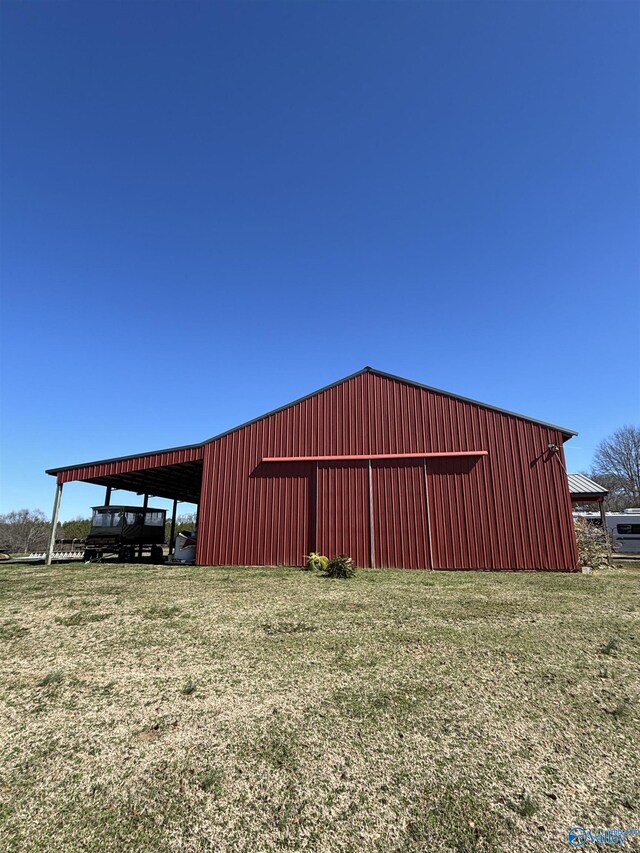 view of pole building with a carport and a yard
