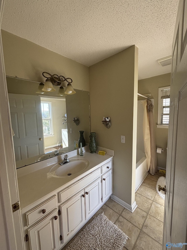 full bath featuring shower / tub combo, vanity, a textured ceiling, and a healthy amount of sunlight