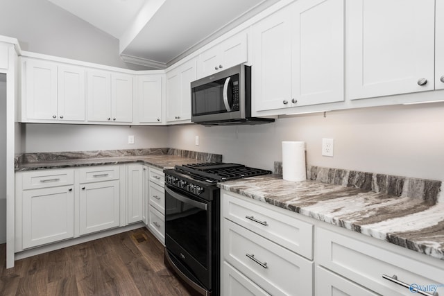 2810 Mountain View Dr, Southside, AL 35907 - kitchen with black range with gas cooktop, stainless steel microwave, vaulted ceiling, dark wood finished floors, and white cabinetry