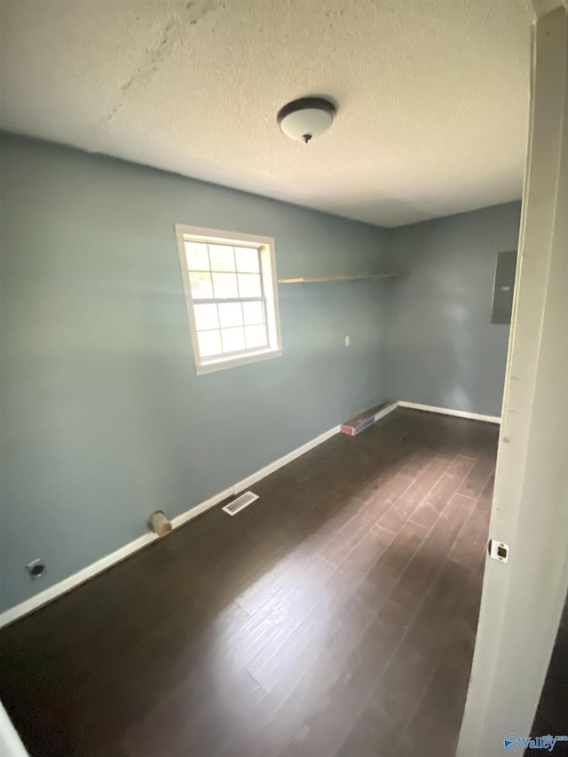 spare room featuring visible vents, baseboards, and wood finished floors