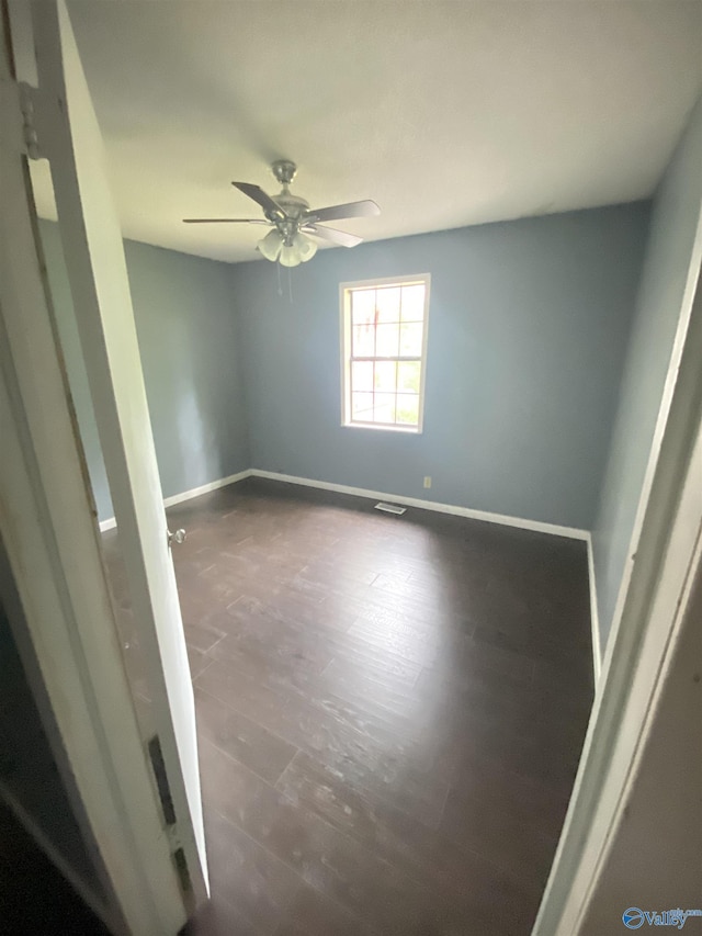 unfurnished room featuring visible vents, ceiling fan, baseboards, and wood finished floors