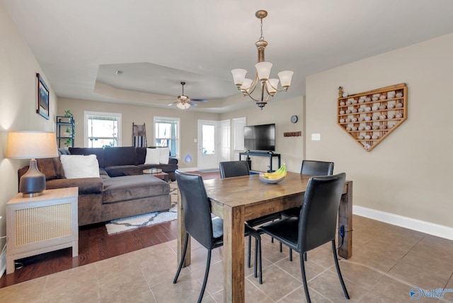 2626 SW Ashtynn Pl, Huntsville, AL 35803 - dining space featuring a chandelier, a tray ceiling, tile patterned floors, and a ceiling fan