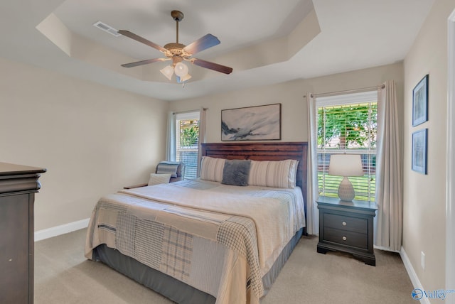 2626 SW Ashtynn Pl, Huntsville, AL 35803 - bedroom with a tray ceiling, light colored carpet, and multiple windows