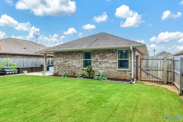 2626 SW Ashtynn Pl, Huntsville, AL 35803 - rear view of house with a fenced backyard, brick siding, a patio area, roof with shingles, and a gate