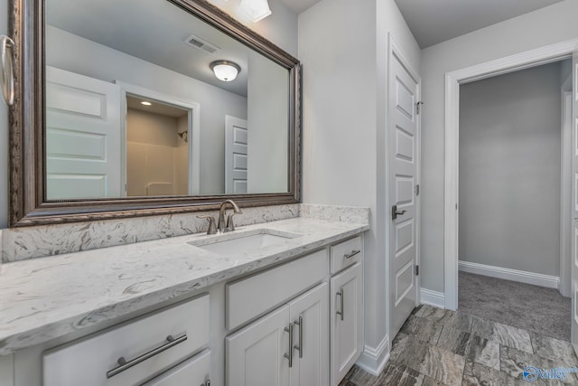 bathroom with walk in shower and vanity