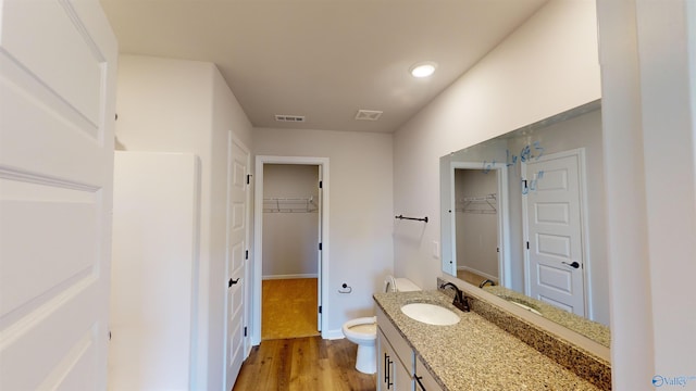 bathroom with toilet, hardwood / wood-style floors, and vanity