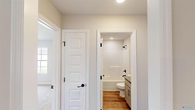 full bathroom featuring hardwood / wood-style floors, vanity, bathing tub / shower combination, and toilet