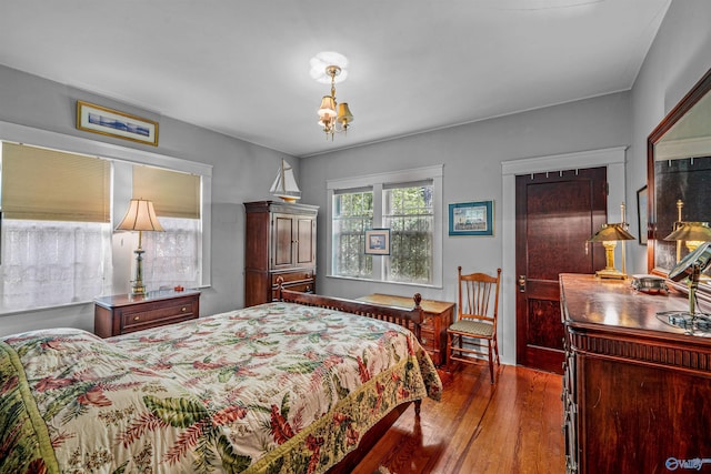 bedroom with a chandelier and hardwood / wood-style floors