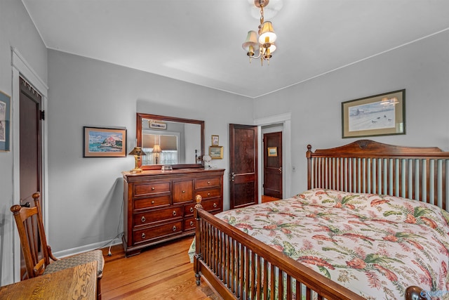 bedroom featuring baseboards, a chandelier, and light wood-style floors