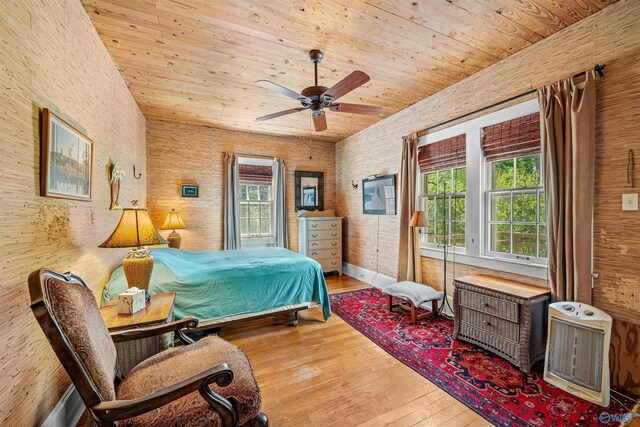 bedroom featuring hardwood / wood-style floors, wooden ceiling, heating unit, and a ceiling fan