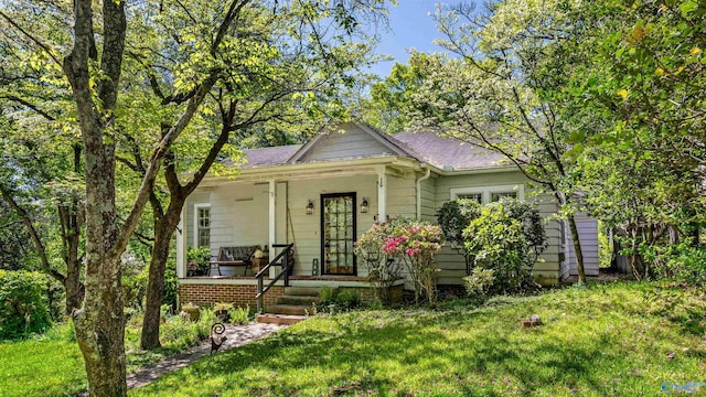 bungalow with a shingled roof, a front lawn, and covered porch