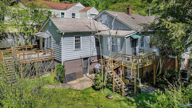 back of house featuring a chimney, a wooden deck, roof with shingles, and stairs
