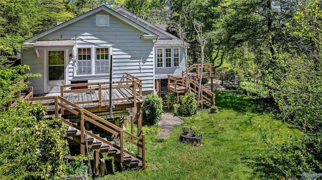 rear view of property featuring a lawn, a wooden deck, and stairway
