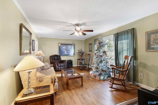 living room with hardwood / wood-style floors, a textured ceiling, ceiling fan, and ornamental molding