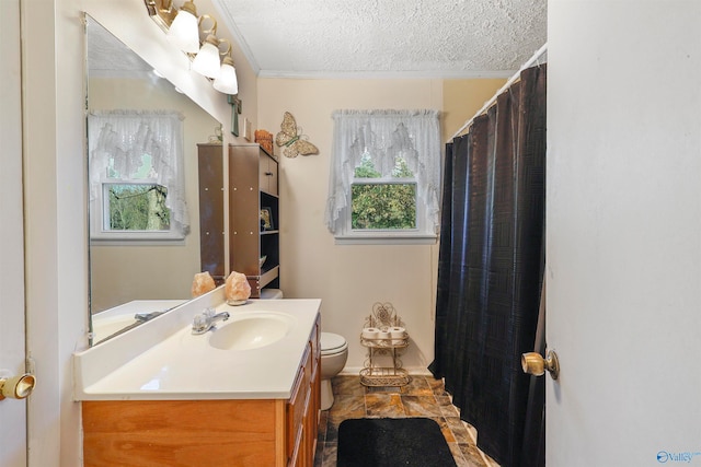 bathroom featuring vanity, toilet, a textured ceiling, and crown molding