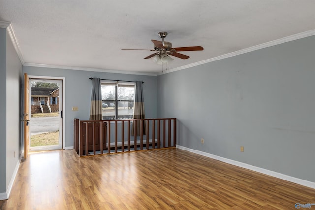 spare room featuring ceiling fan, hardwood / wood-style flooring, and crown molding