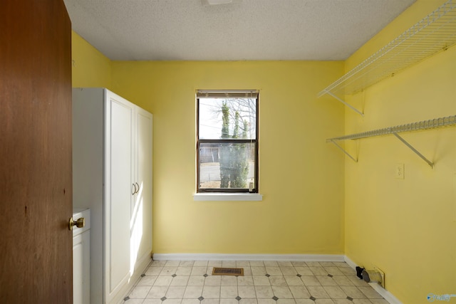 washroom with a textured ceiling, cabinets, and hookup for a washing machine