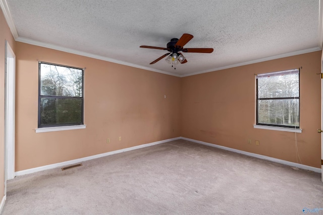 carpeted spare room with a textured ceiling, crown molding, and ceiling fan