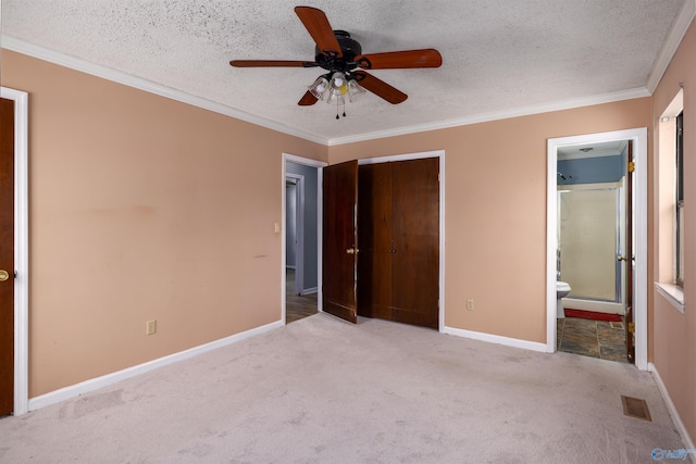 unfurnished bedroom with ornamental molding, light carpet, a textured ceiling, and a closet