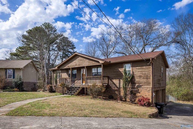 ranch-style house featuring covered porch and a front yard