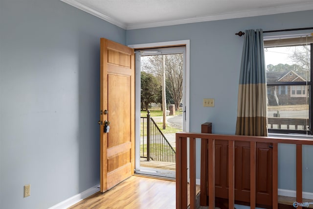 doorway with ornamental molding and light hardwood / wood-style flooring