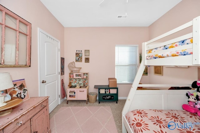 bedroom with baseboards, visible vents, and light colored carpet