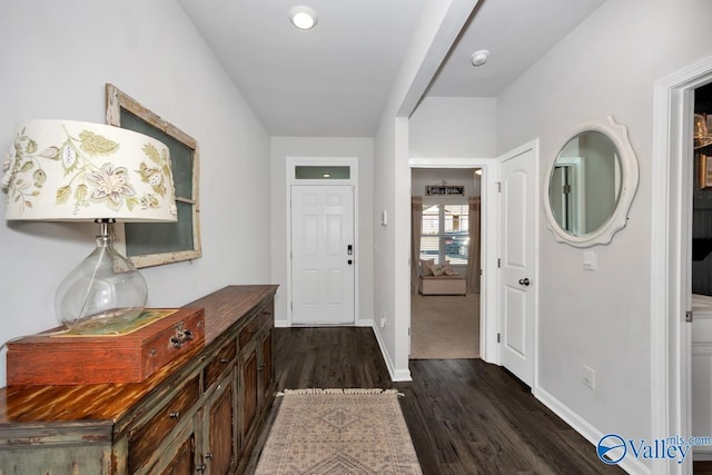 entryway with dark wood-type flooring and baseboards