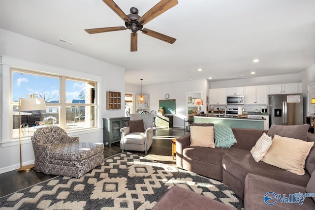 living area featuring baseboards, dark wood finished floors, visible vents, and recessed lighting