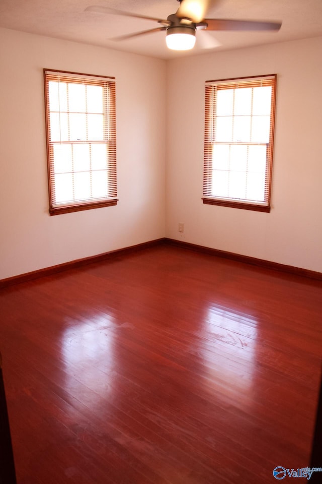 spare room with ceiling fan, wood-type flooring, and a wealth of natural light