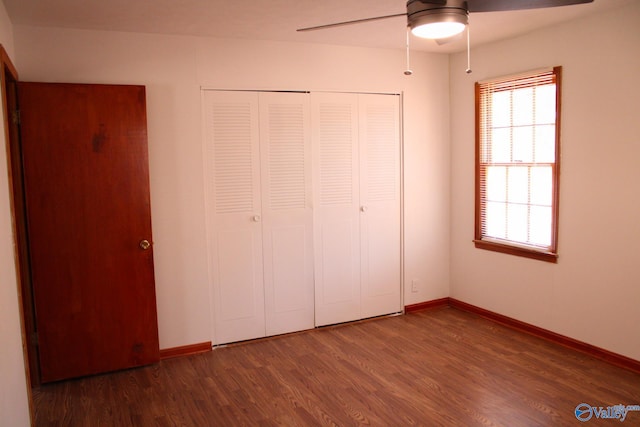 unfurnished bedroom featuring a closet, ceiling fan, and dark hardwood / wood-style flooring