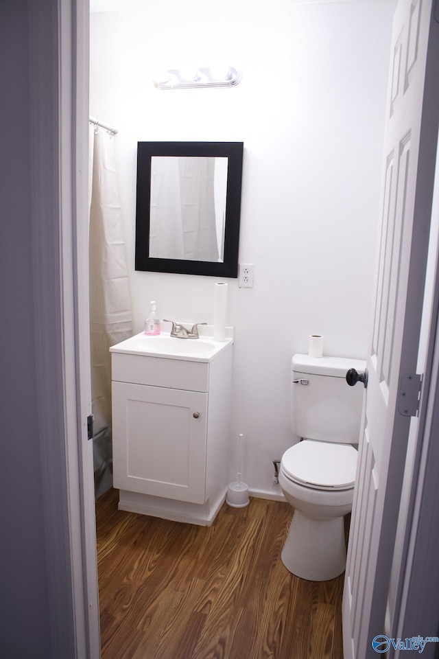 bathroom with hardwood / wood-style floors, vanity, and toilet