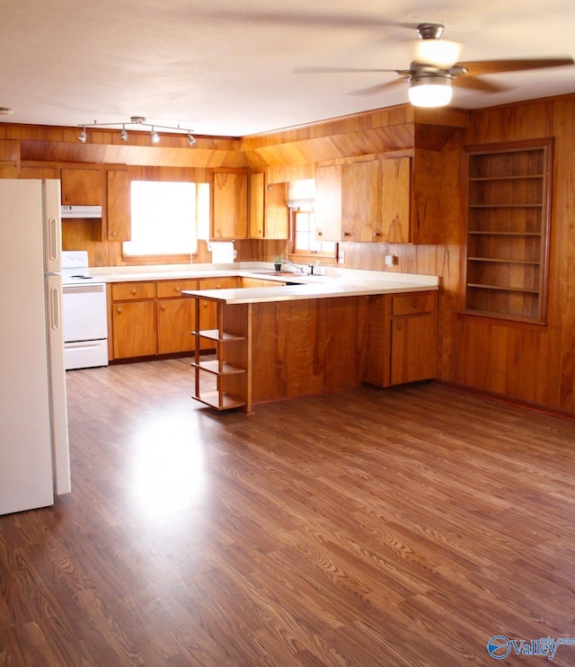 kitchen with dark hardwood / wood-style flooring, built in features, white refrigerator, kitchen peninsula, and stove