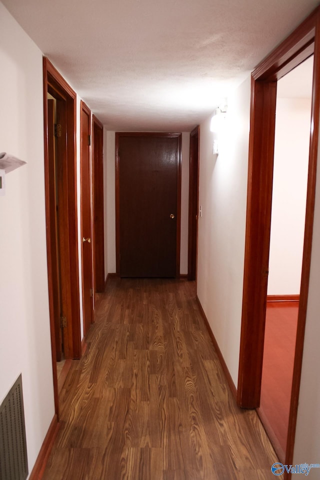 hallway with dark hardwood / wood-style flooring