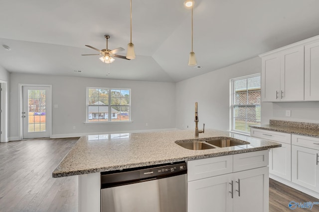 kitchen featuring light stone counters, stainless steel dishwasher, open floor plan, white cabinets, and a sink