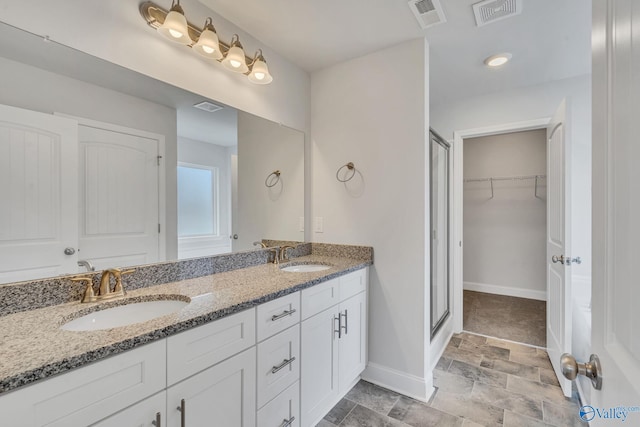 full bath featuring a walk in closet, visible vents, and a sink