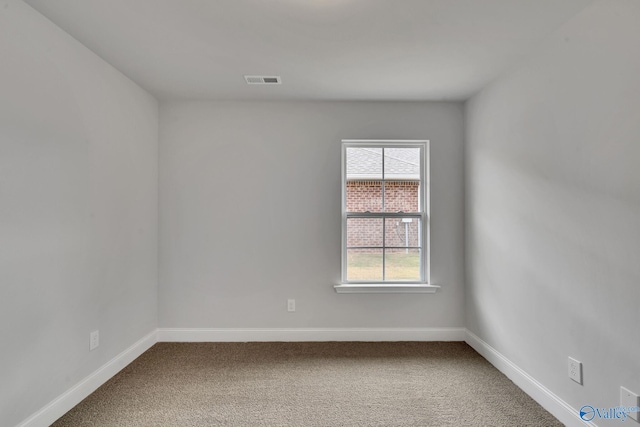 carpeted empty room featuring baseboards and visible vents