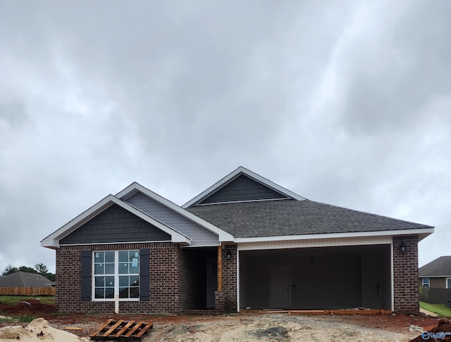 view of front of house featuring a garage, brick siding, and a shingled roof