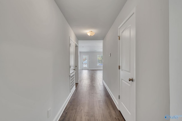 hallway with dark wood-style floors and baseboards