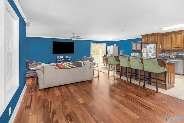 living room with ceiling fan, hardwood / wood-style flooring, and ornamental molding