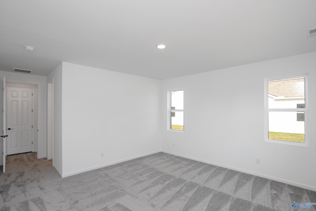 unfurnished room with plenty of natural light and light carpet