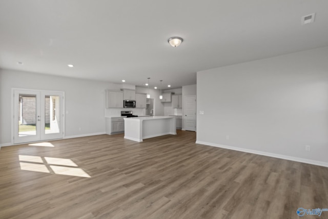 unfurnished living room with french doors and light hardwood / wood-style floors