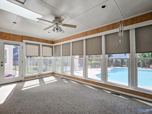 spare room featuring ceiling fan, carpet floors, and a healthy amount of sunlight