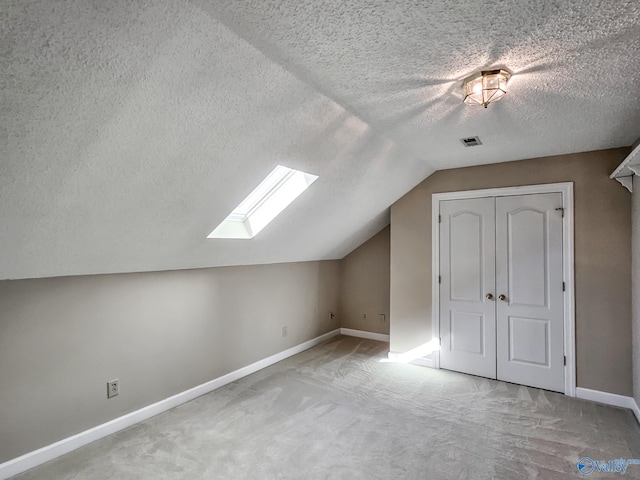 bonus room featuring a textured ceiling, carpet floors, and lofted ceiling with skylight