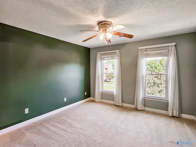 carpeted empty room with a textured ceiling and ceiling fan