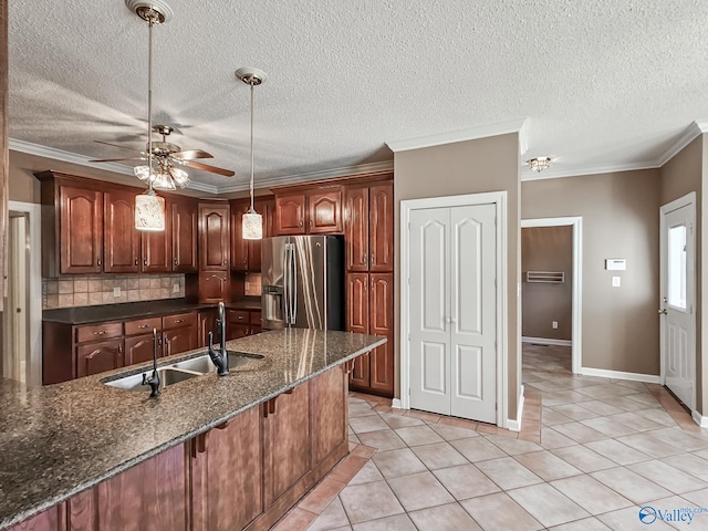 kitchen with ornamental molding, pendant lighting, sink, and stainless steel fridge with ice dispenser