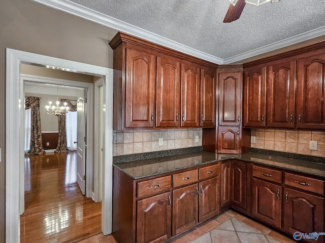 kitchen with a textured ceiling, crown molding, decorative backsplash, and light hardwood / wood-style flooring