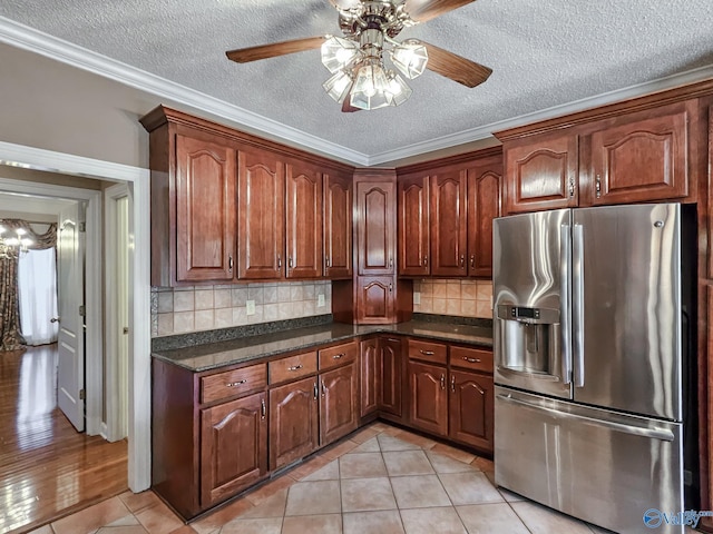 kitchen with a textured ceiling, light tile patterned flooring, crown molding, ceiling fan, and stainless steel fridge